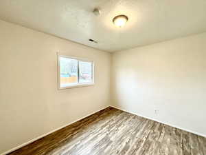 Spare room featuring wood finished floors and baseboards