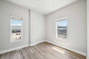 Spare room featuring wood finished floors and baseboards