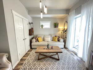 Living area with dark wood-style floors and beamed ceiling