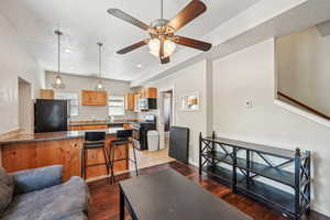 Living room with a textured ceiling, wood finished floors, a ceiling fan, baseboards, and recessed lighting