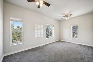 Spare room with a ceiling fan, carpet flooring, and baseboards