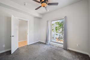 Spare room featuring carpet, a ceiling fan, and baseboards