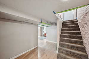 Stairs featuring wood finished floors and baseboards