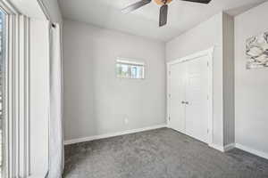 Unfurnished bedroom with carpet flooring, baseboards, a ceiling fan, and a closet