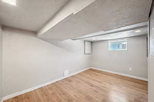 Below grade area featuring wood finished floors and baseboards