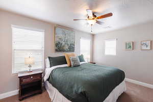 Carpeted bedroom with baseboards and ceiling fan