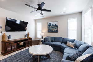 Living area featuring light tile patterned floors, a ceiling fan, healthy amount of natural light, and recessed lighting