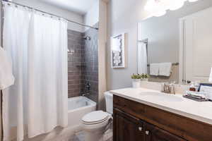 Bathroom featuring toilet, shower / bath combo, vanity, and tile patterned floors