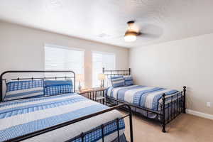 Bedroom featuring light colored carpet, a ceiling fan, and baseboards