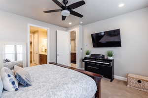 Bedroom with light carpet, ensuite bath, recessed lighting, baseboards, and a ceiling fan