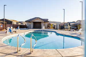 Community pool featuring fence, a patio area, and a residential view
