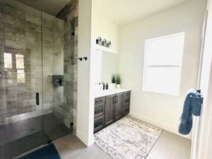 Bathroom with a shower stall, vanity, and baseboards