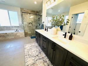 Full bath with a bath, a tile shower, tile patterned flooring, and double vanity