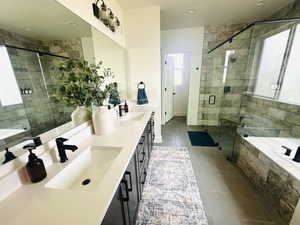 Bathroom with tile patterned flooring, a shower stall, double vanity, and a garden tub