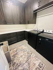 Laundry room with cabinet space, washer and clothes dryer, and light tile patterned floors
