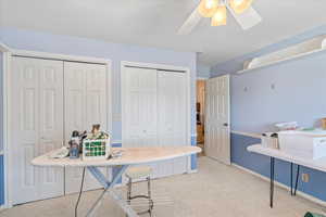 Bedroom with ceiling fan, baseboards, and carpet flooring