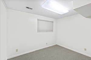 Spare room with carpet and baseboards