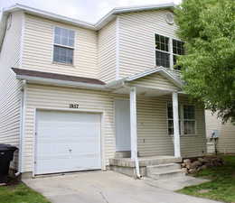 View of front of house with a garage, covered porch, and driveway