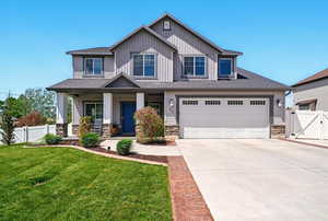 Craftsman house featuring stone siding, concrete driveway, and a gate