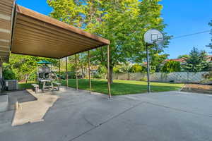 View of patio with a playground and covered patio