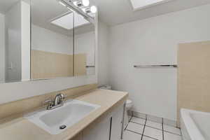 Bathroom featuring toilet, tile patterned floors, a bathtub, and vanity