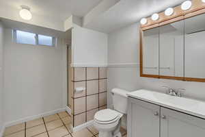 Full bathroom featuring toilet, a shower stall, vanity, and tile patterned floors
