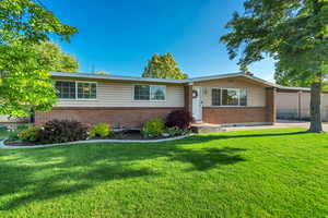 Single story home with brick siding and a front lawn