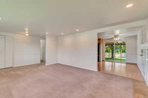 Unfurnished room with a ceiling fan, recessed lighting, light colored carpet, and baseboards