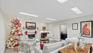Living area with wood finished floors, a fireplace, and baseboards