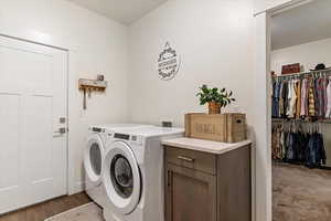 Laundry area featuring washing machine and clothes dryer and wood finished floors