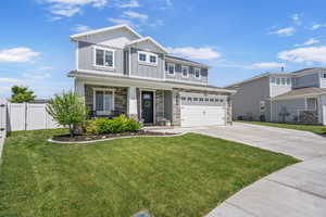 Craftsman house with board and batten siding, stone siding, driveway, a 2 car garage,  a covered porch and RV pad