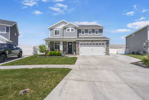 View of front  with a gate, driveway, stone siding, attached garage and RV Pad