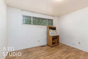 Spare room featuring wood finished floors and baseboards