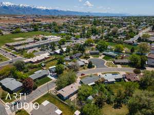 Aerial view of property and surrounding area with a mountainous background and nearby suburban area