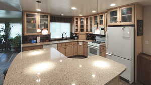Kitchen featuring white appliances, a sink, healthy amount of natural light, recessed lighting, and decorative backsplash