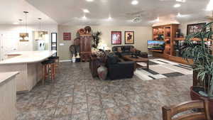 Living room with washer / dryer, recessed lighting, baseboards, stone finish flooring, and a ceiling fan