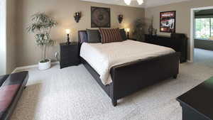 Bedroom featuring light carpet and baseboards