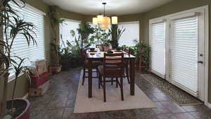 Dining area featuring baseboards and a chandelier