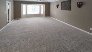 Spare room featuring baseboards and carpet flooring