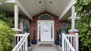 Doorway to property featuring brick siding