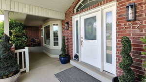 Entrance to property with brick siding and covered porch