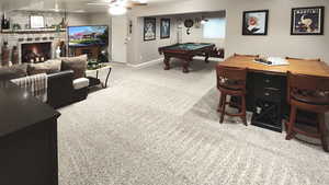 Playroom with carpet, a stone fireplace, billiards table, baseboards, and ceiling fan