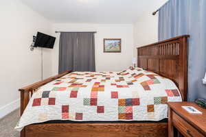 Bedroom featuring carpet floors and baseboards