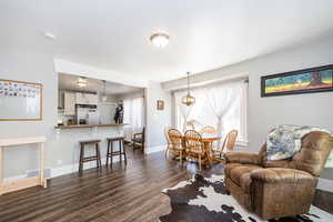 Living area with dark wood-type flooring and baseboards