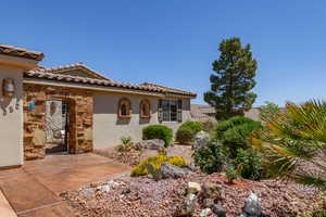 View of front of property featuring stone siding, a tiled roof, and stucco siding