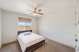 Bedroom featuring carpet floors, baseboards, and a ceiling fan