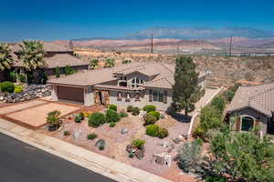View of front of property with a mountain view, a tiled roof, a garage, and stucco siding