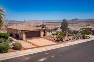 Mediterranean / spanish-style house featuring a tiled roof, stucco siding, a mountain view, an attached garage, and concrete driveway