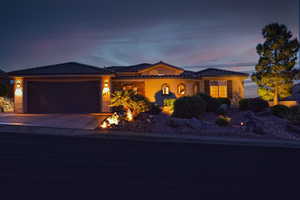 View of front facade featuring a tiled roof, a garage, stucco siding, and concrete driveway