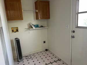 Laundry area with hookup for a washing machine, electric dryer hookup, baseboards, and cabinet space